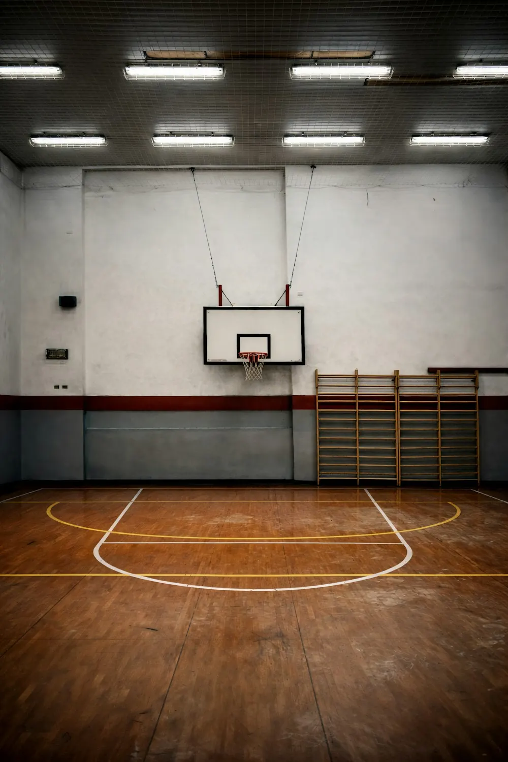 Empty school gymnasium with a basketball hoop