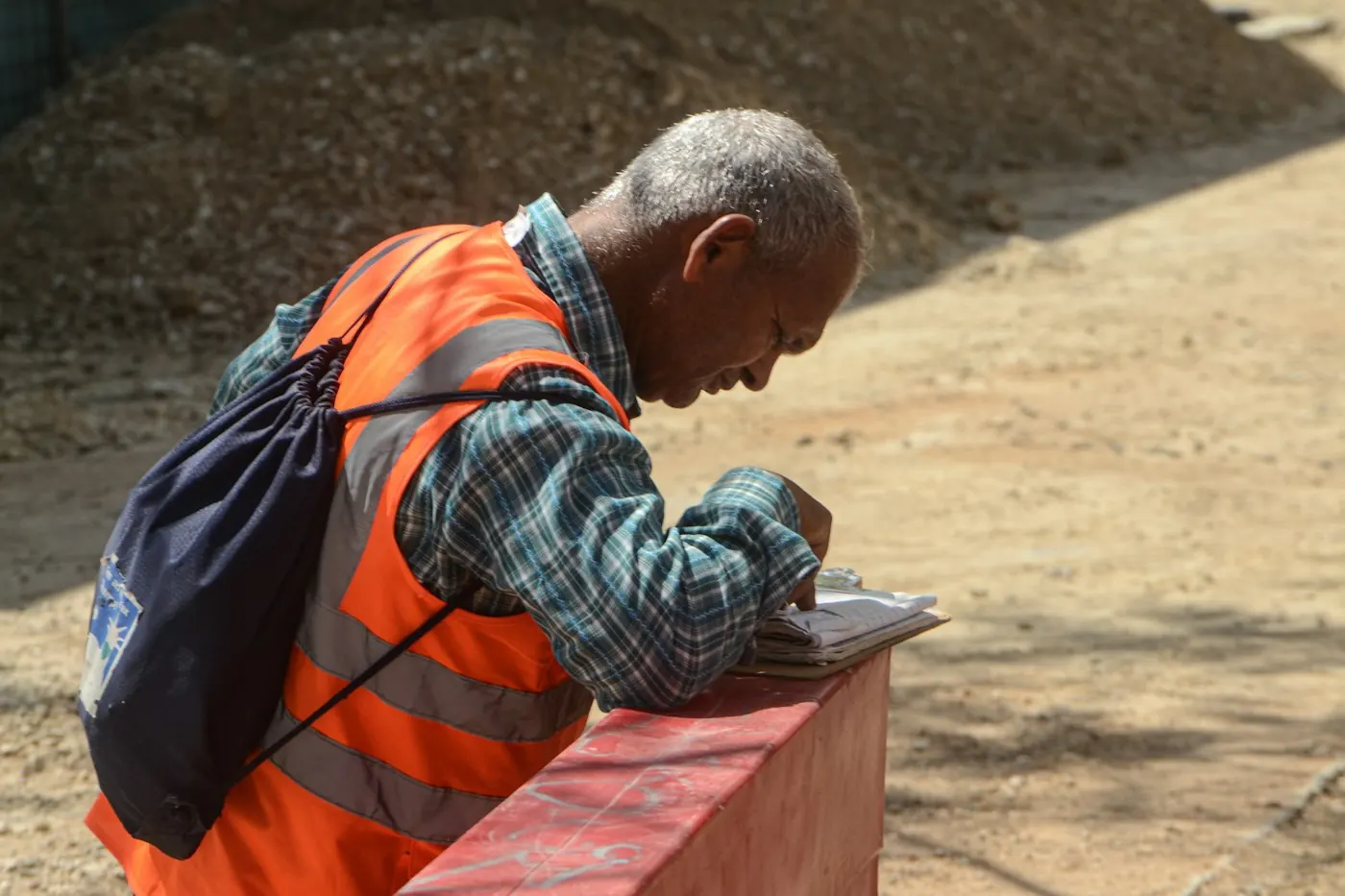 Worker in a high-visibility vest writing inspection notes