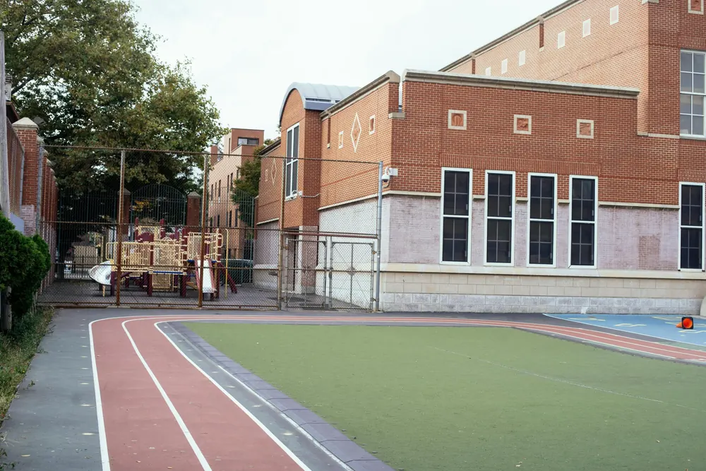 School building beside a running track and sports field