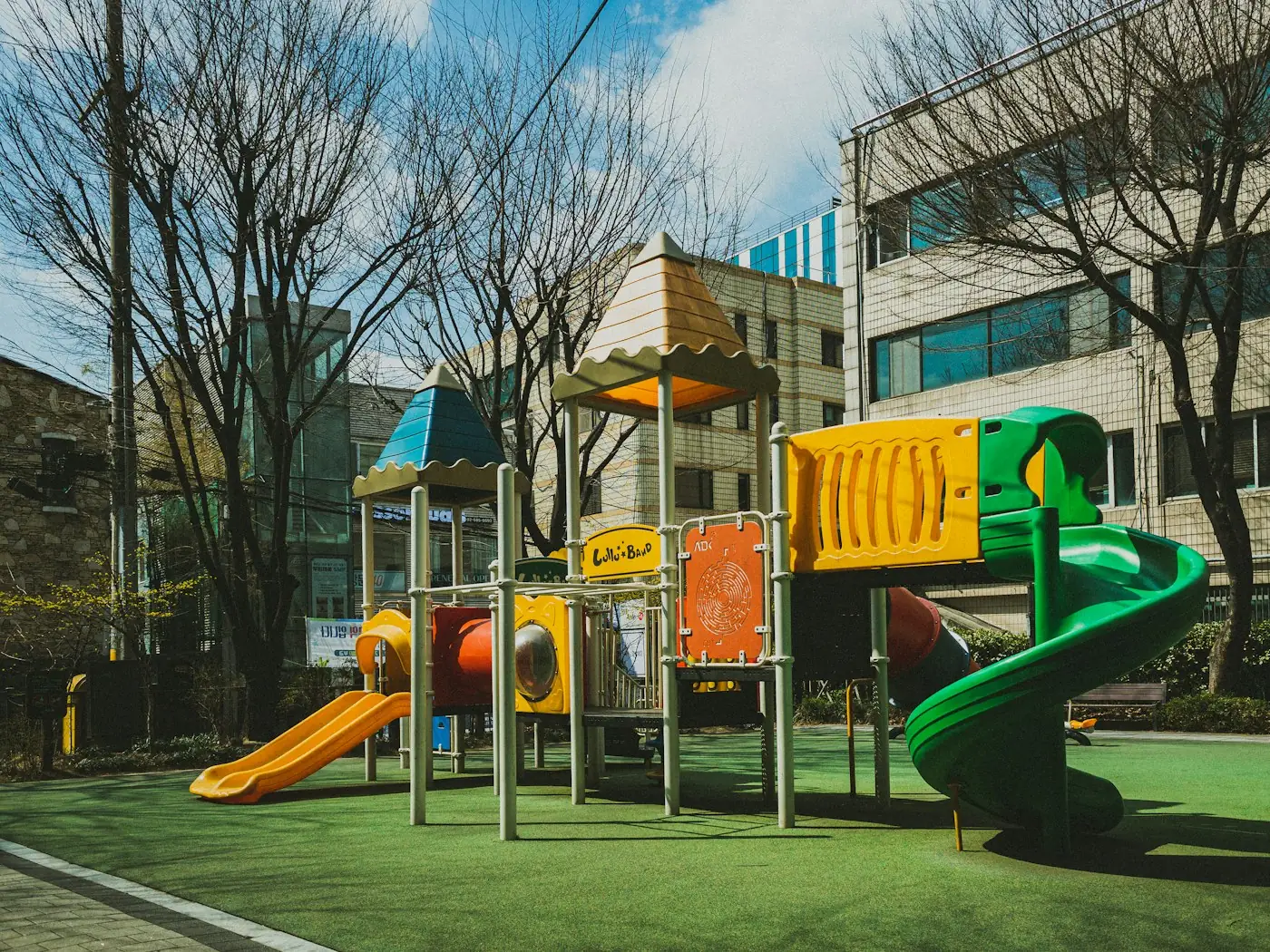 School playground structure with slides beside a building
