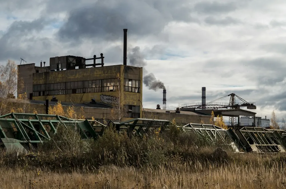 Aging industrial building with smokestacks under a cloudy sky